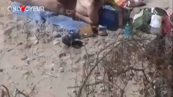 Beach Voyeur. Young nudist couple enjoying sex on the beach