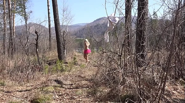 Fusion with nature in the outdoors. Blonde with a big ass strips in the forest and with a bare natural hairy pussy playing with a spruce twig.